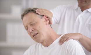 Een man met osteochondrose van de nek bij de receptie van een manueel masseur